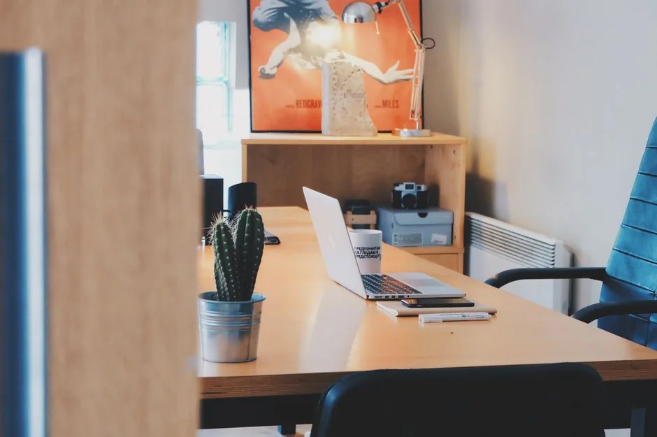 A laptop on a bed showing web design software, creating a cozy workspace.